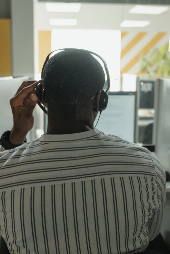 African American man with headset providing customer service in modern call center.