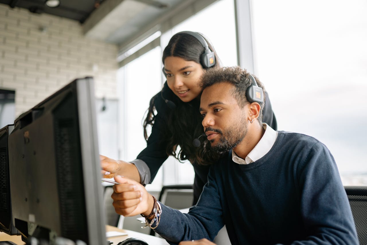Crafting Captivating Headlines: Your awesome post title goes here Two call center employees working together with headsets in a modern office setting.